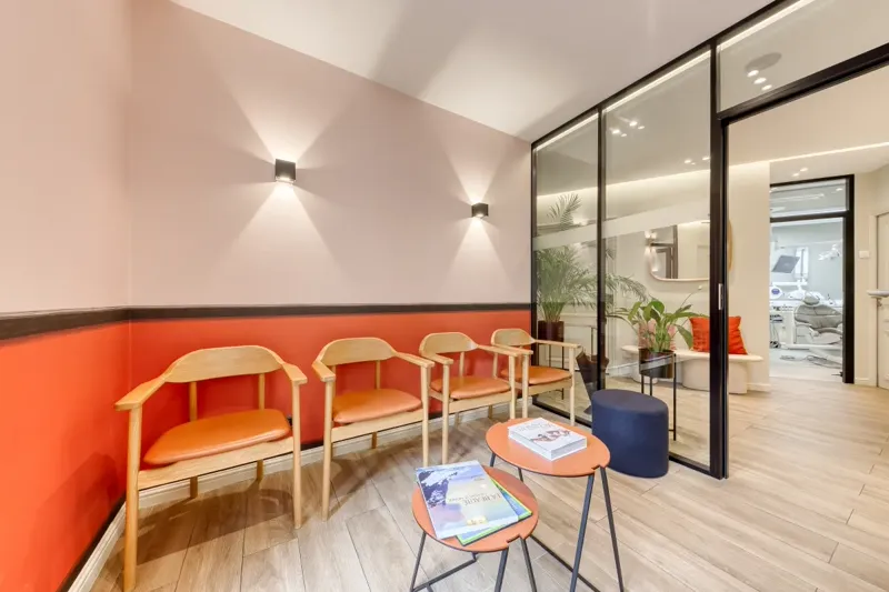 Salle d'attente aux murs corail et mobilier en bois